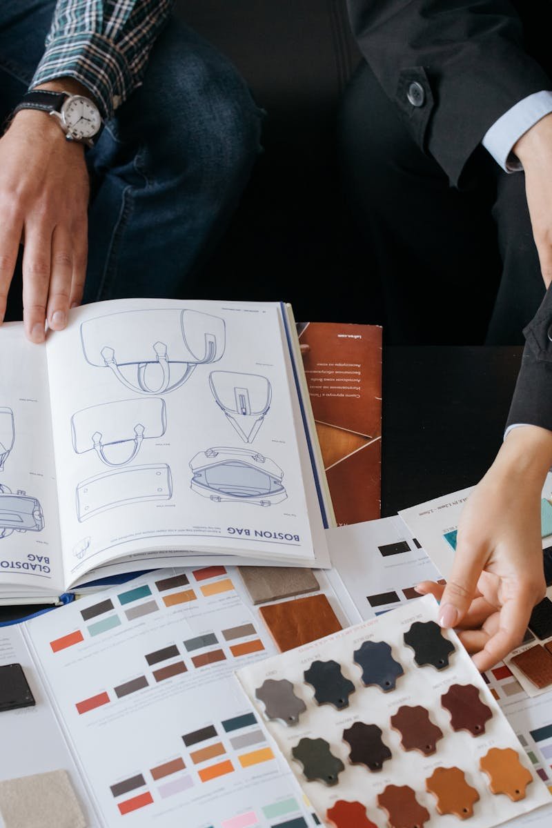 Two professionals choosing color swatches and bag designs for a fashion project.